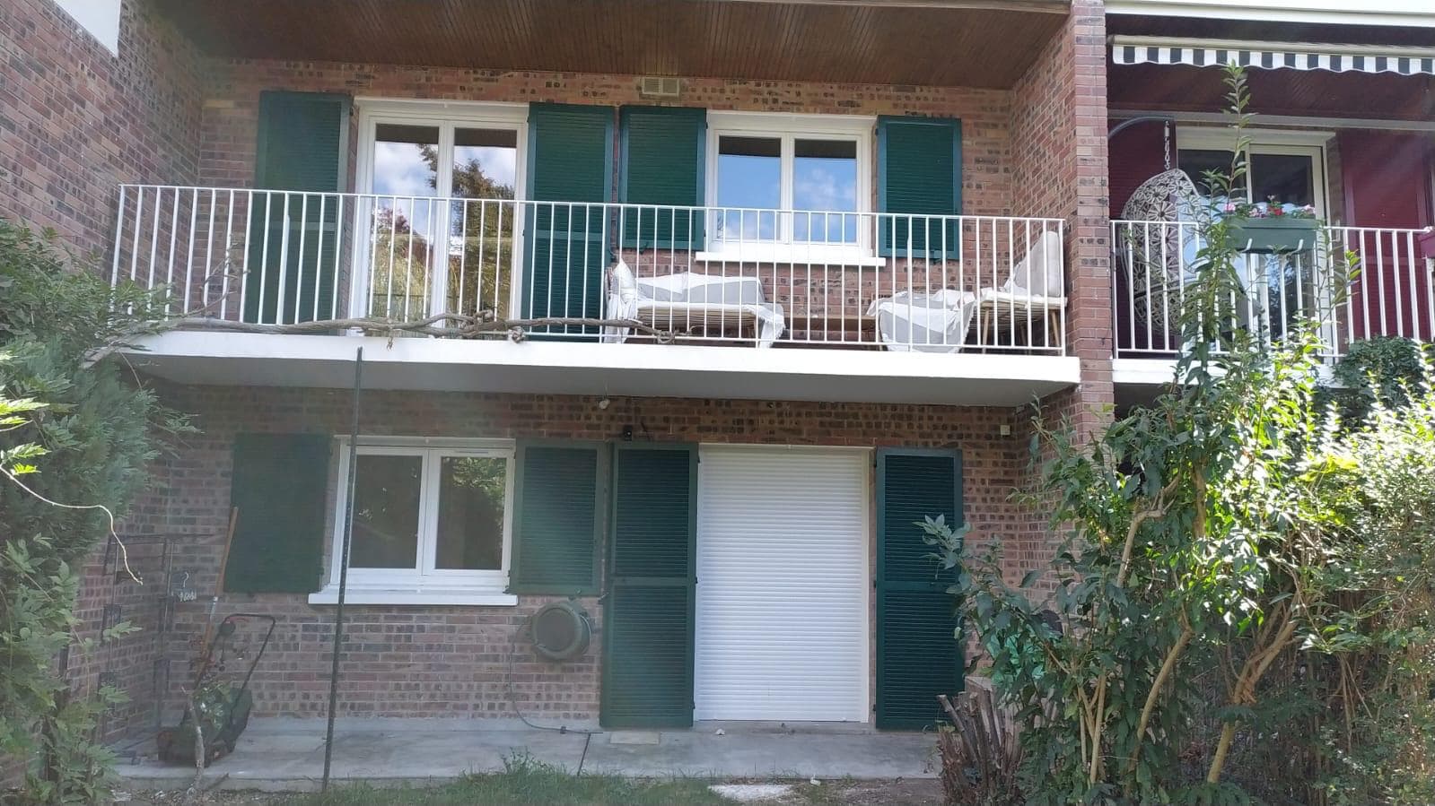 Façade côté jardin avec volets verts rénovés